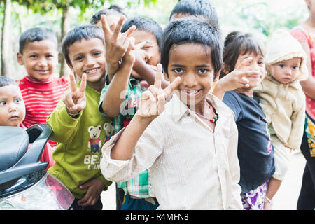 SAURAHA, NEPAL - APRIL 2015: portrait of Nepali children showing peace sign in Chitwan national park. Stock Photo