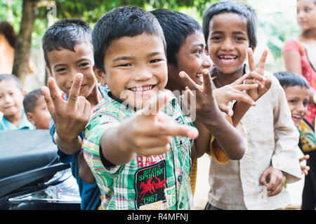 SAURAHA, NEPAL - APRIL 2015: portrait of Nepali children showing peace sign in Chitwan national park. Stock Photo