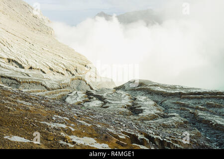 Sulfuric cloud around turquoise lake out from Ijen mountains crater Banyuwangi, Indonesia Stock Photo