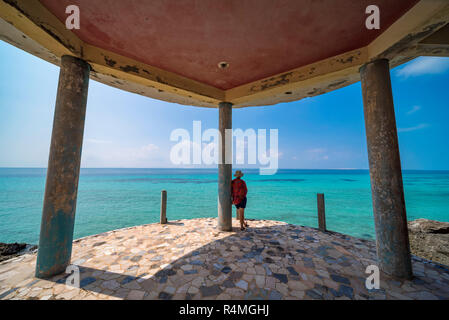 A tiorist explores the abandoned buildings of Santa Carolina Hotel on Paradise iIsland in MOzambique's Bazaruto Archipelago. Stock Photo