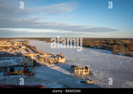 View on top of the quarry mountain with sunny wather and snow. Houses submerged in lake below. Stock Photo