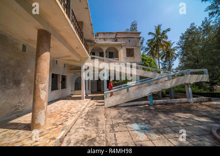 A tiorist explores the abandoned buildings of Santa Carolina Hotel on Paradise iIsland in MOzambique's Bazaruto Archipelago. Stock Photo