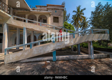 A tiorist explores the abandoned buildings of Santa Carolina Hotel on Paradise iIsland in MOzambique's Bazaruto Archipelago. Stock Photo