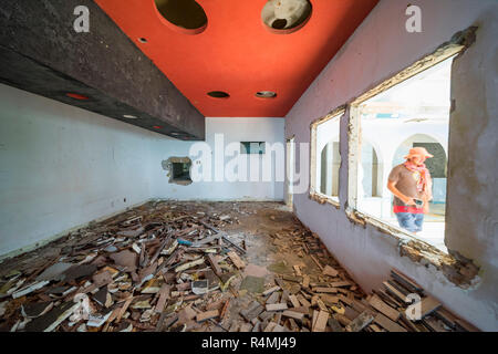 A tiorist explores the abandoned buildings of Santa Carolina Hotel on Paradise iIsland in MOzambique's Bazaruto Archipelago. Stock Photo