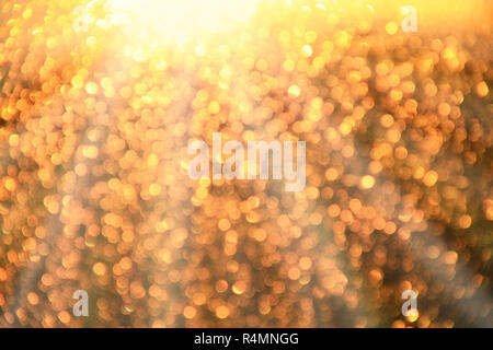 Golden bokeh. Texture with gold abstraction. Creative abstract golden patterned background. A lot of gold bokeh. Bright rays Stock Photo