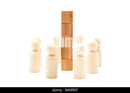 Wooden figures as business team in circle around tower of wood cubes, isolated on white background, minimalist concept Stock Photo