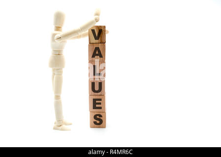Wooden figure as businessman building Values as tower of wood cubes, isolated on white background, minimalist concept Stock Photo
