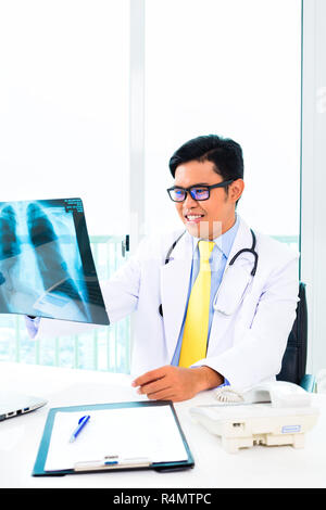 Asian doctor examining x-ray picture in practise Stock Photo