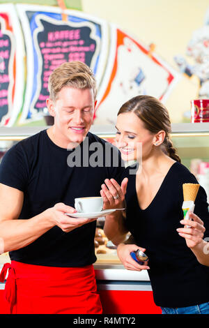 Ice cream seller and waiter working in cafe Stock Photo