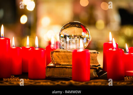 Crystal ball in the candle light to prophesy Stock Photo