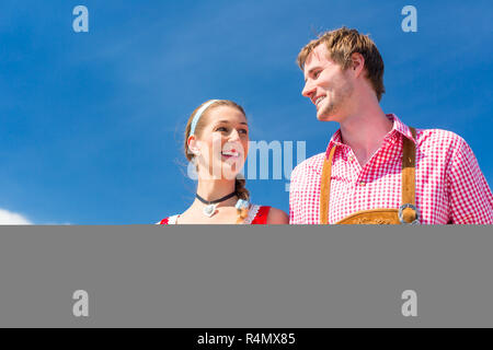 Couple visiting Bavarian fair having fun Stock Photo