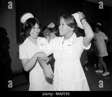 Two nurses are together after their graduation ceremony in California, ca. 1976. Stock Photo
