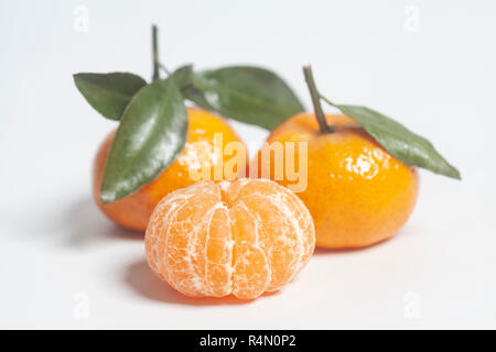 Ripe mandarins with green leaves on white background Stock Photo