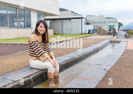 Young Woman enjoy foot onsen with cat at outdoor Stock Photo