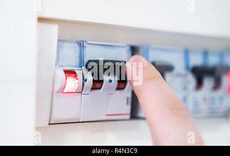 Male hand switching off fuse board. Stock Photo