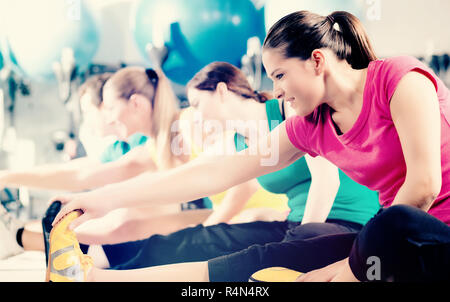 People in gym warming up stretching Stock Photo