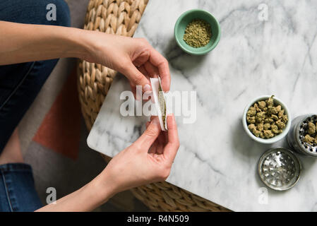 Hands of woman rolling marijuana joint Stock Photo