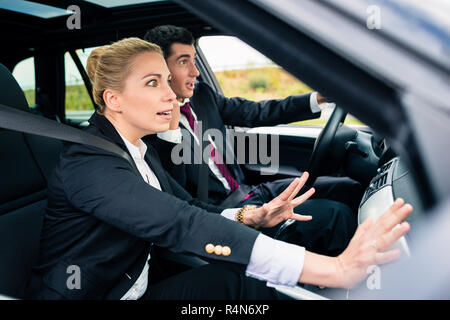 Couple in car in dangerous situation Stock Photo