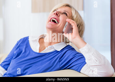 Senior woman phone at home sitting on couch Stock Photo