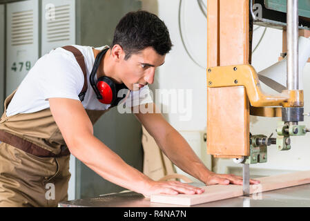 Carpenter cutting board with jig saw on his workbench Stock Photo