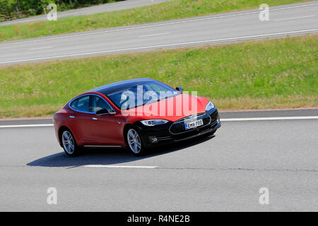 Paimio, Finland - June 1, 2018: Red and black Tesla Model S electric car at speed on freeway in South of Finland on a day of summer. Stock Photo