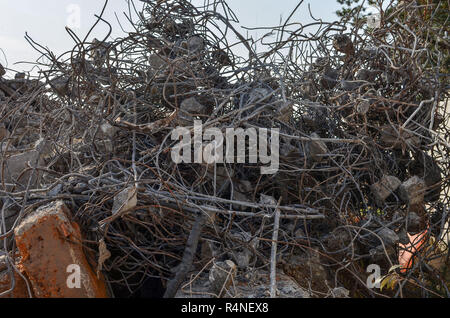 A heap of construction debris: Armature, iron round rods, pieces of broken concrete, curved metal rods. The remnants of broken pieces after the demoli Stock Photo