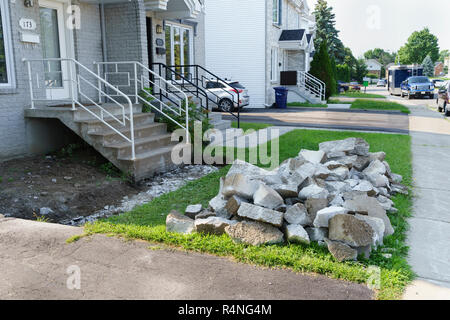 Pile of concrete debris left after the demolition of an alley leading to the front entrance of a suburban house. Stock Photo