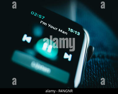 Space grey Apple Watch 4 on a blue jeans, playing I'm your man. Lovely green and blue tones and textures. Stock Photo