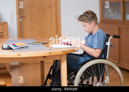 boy in wheelchair doing homework Stock Photo