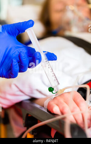 Paramedic giving infusion in ambulance Stock Photo