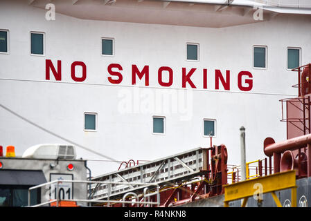 Hazardous habit, Big painted red letter sign on the bridge of a large ocean going ship tells the crew No Smoking. Stock Photo