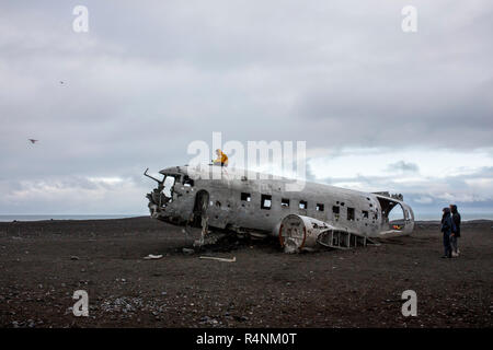 A tourist takes selfies with a drone as he sits on top of the wreckage of a US Navy DC plane that crash landed on a beach in Southern Iceland on November 21, 1973. The place crashed as a result of either low fuel or icing on the engines and all aboard survived. After the crash the Navy stripped the plane of engines and other valuable components but left the main fuselage on the black sand beach near Solheimasandur. Today, due in large part to geotagging from Instagram, the plane is a popular destination for photographers and adventure enthusiasts visiting Iceland. Stock Photo