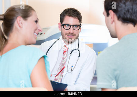 Pregnant woman and her partner seeing physician Stock Photo