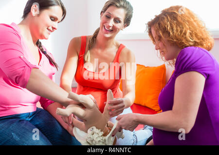 Midwife explaining birth process to pregnant women during antenatal class Stock Photo