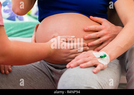 Midwife or nurse feeling baby belly of pregnant woman Stock Photo
