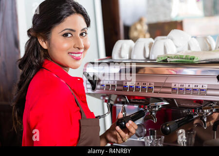 Barista woman making coffee in cafe with machine Stock Photo