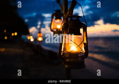 Sunset on island beach with lanterns Stock Photo