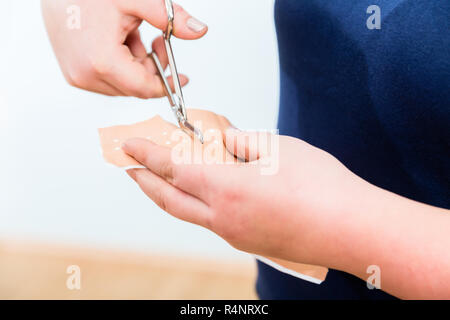 In First aid class, Cutting of patch for smaller lesions Stock Photo