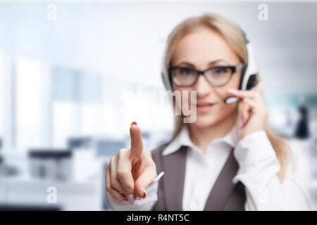 Three call center service operators at work. Portrait of smiling pretty female helpdesk employee with headset at workplace. Stock Photo