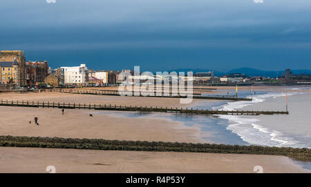 Portobello, Edinburgh, Scotland, United Kingdom, 28th November 2018. UK Weather: Dark storm clouds gather over people walking dogs on the sandy beach at Portobello as Storm Diana approaches. The beach has wooden groynes to protect the shore Stock Photo