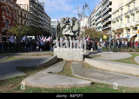 Thessaloniki, Greece, 28th November, 2018. Protesters from the communist-affiliated trade union PAME walk past a statue during a 24-hour walkout staged by Greece's largest private sector union GSEE  against planned pension cuts and to demand the reversal of labour reforms implemented under the country's third bailout. The strike by the GSEE union is the second major strike since Greece exited its bailout programm in August. Credit : Orhan Tsolak / Alamy Live News. Stock Photo