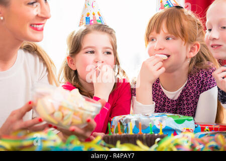 Children on birthday party nibbling candies Stock Photo