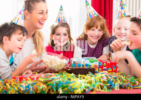 Children on birthday party nibbling candies Stock Photo