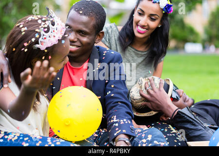 Indian girl and african couple celebrating together on street party Stock Photo