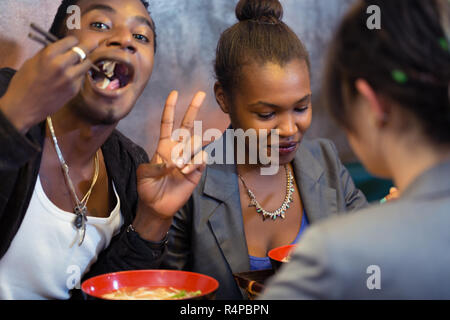 Group of young black people dining in Asian restaurant