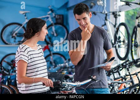 Couple looking for bicycle in bike shop Stock Photo