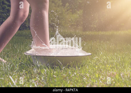 Little boy and splash of water in the summer garden Stock Photo