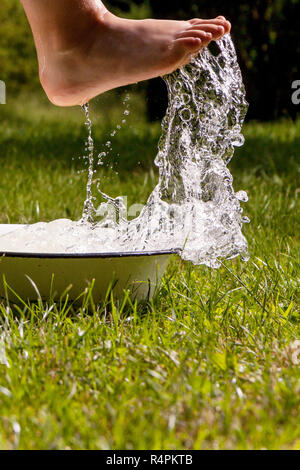 Little boy and splash of water in the summer garden Stock Photo