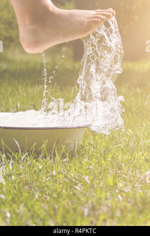 Little boy and splash of water in the summer garden Stock Photo