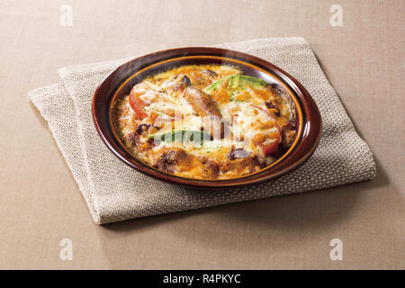 Cheese cake in black bowl with saussage mushroom and vegetables Stock Photo